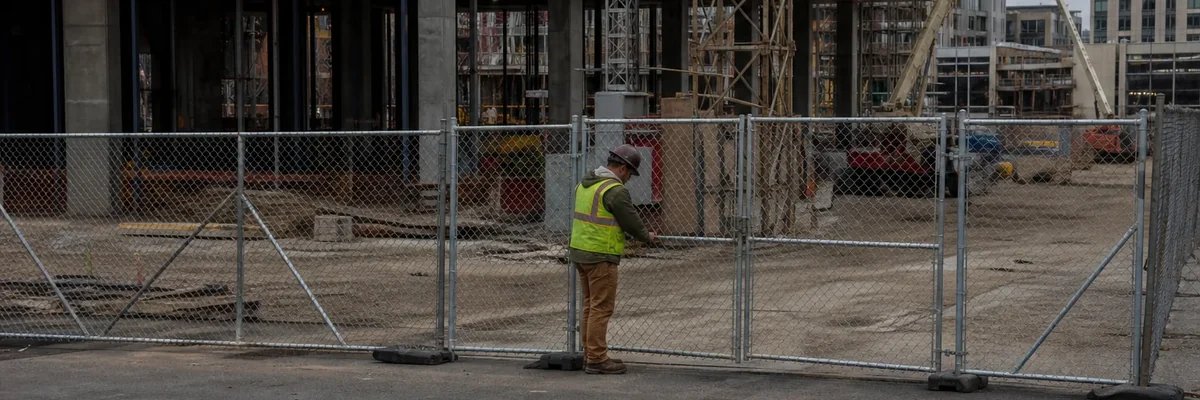 Portable chain-link fencing securing an active construction site