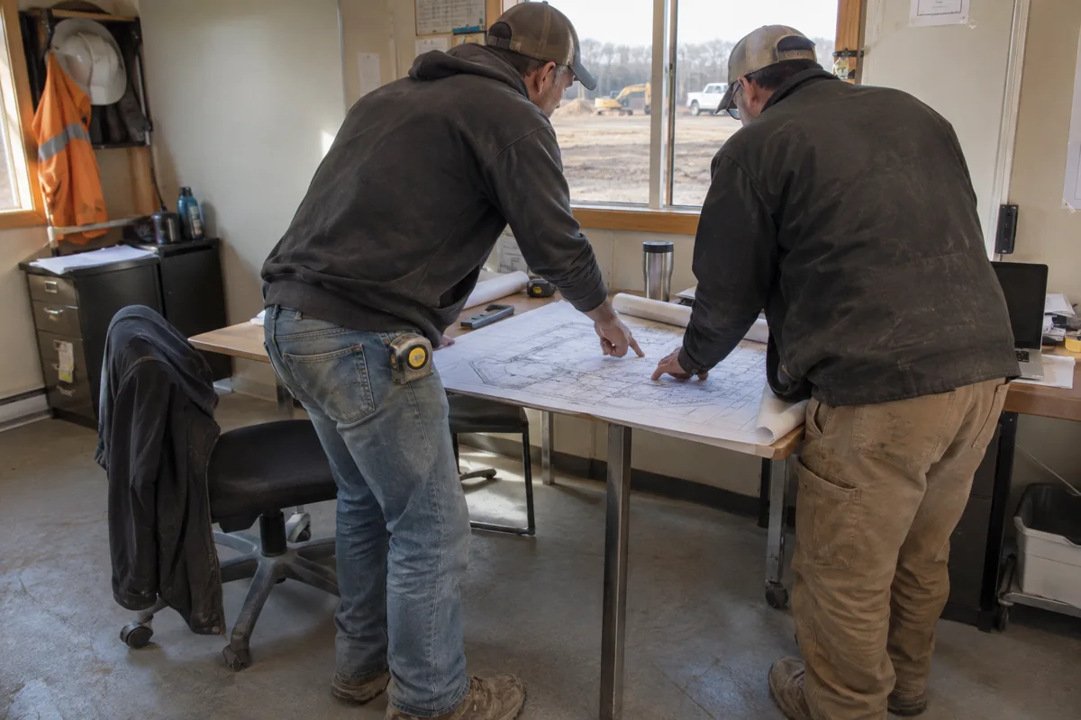 Workers discussing a site plan inside a modular office